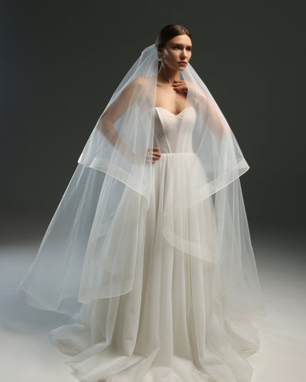 Ivory bridal veil made from soft English tulle, fingertip length, featuring two layers and a horsehair trim.