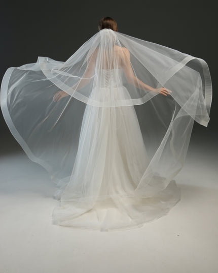 Ivory bridal veil made from soft English tulle, fingertip length, featuring two layers and a horsehair trim.